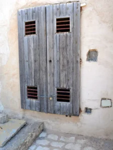 A boarded up window with a lock at the bottom